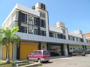 un edificio con un furgone rosa parcheggiato in un parcheggio di Labuk Hotel a Sandakan