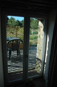 a sliding glass door with a table on a patio at Chambre d'Hôte La Boulière in Martigné-Ferchaud