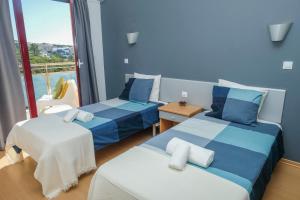 a hotel room with two beds and a balcony at Summer in Paradise - Sea View and Pool in Ericeira in Ericeira