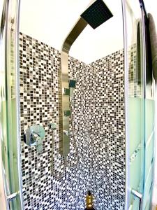 ein Badezimmer mit Dusche mit schwarz-weißen Fliesen in der Unterkunft Domus Delphi in Rom + 27 Fotos