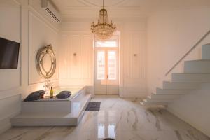 a white hallway with a chandelier and a staircase at JACUZZI SINAGOGA view in Budapest