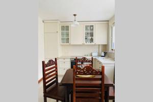 a kitchen with white cabinets and a table and chairs at Apartament Stylowy Pruszków Centrum in Pruszków +16 photos