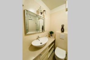 a bathroom with a sink and a toilet and a mirror at Apartament Stylowy Pruszków Centrum in Pruszków