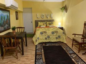 a bedroom with a bed with a love sign on the wall at Hotel Cana Palma Zona Colonial in Santo Domingo