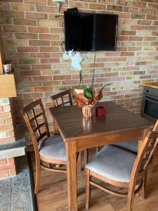a wooden table with chairs and a tv on a brick wall at Katarino Mountain House in Razlog