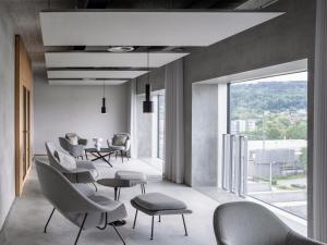 uma sala de espera com cadeiras e mesas e uma grande janela em Placid Hotel Design & Lifestyle Zurich em Zurique