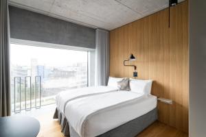 um quarto com uma cama grande e uma janela grande em Placid Hotel Design & Lifestyle Zurich em Zurique mais 37 fotografias