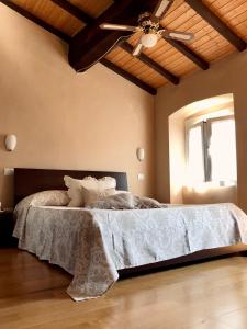 a bedroom with a bed with a ceiling fan at B&B in Piazzetta in Sarzana