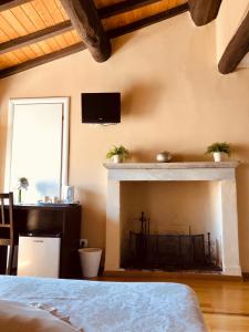 サルザーナにあるB&B in Piazzettaのベッドルーム1室(暖炉、壁掛けテレビ付)