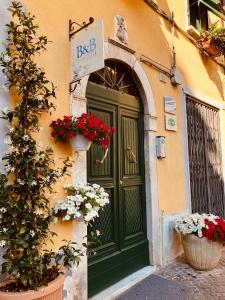 サルザーナにあるB&B in Piazzettaの花の咲く緑の扉のある建物