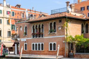 un edificio de ladrillo rojo con flores en las ventanas en Palazzina Veneziana, en Venecia