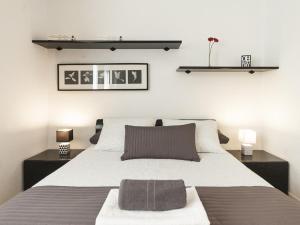 Lets holidays apartment in Sant Martí في برشلونة: غرفة نوم بسرير كبير مع مواقف ليلتين