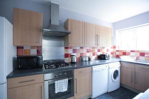 a kitchen with wooden cabinets and a stove top oven at Honest Hospital House Apartment 1 in Southampton
