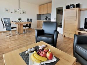 ein Wohnzimmer mit einem Tisch und einem Obstteller in der Unterkunft Appartement 31 - Strandkorb in Timmendorfer Strand
