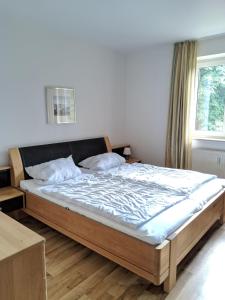ein großes Bett in einem Schlafzimmer mit Fenster in der Unterkunft Appartement 31 - Strandkorb in Timmendorfer Strand