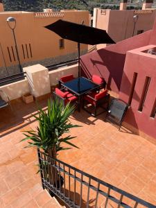 patio con tavolo, sedie e ombrellone di S&H La Consentida a San Juan de los Terreros
