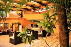 a lobby with palm trees and people sitting in chairs at Maya Tulipanes Express in Palenque