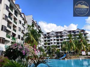 a view of a resort with a swimming pool and palm trees at Wan's Apartment Bayu Beach Resort in Kampong Si Rusa