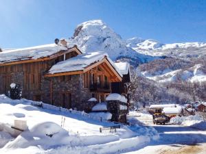 a snow covered cabin with a mountain in the background at Le Chalet in Saint-Martin-de-Belleville