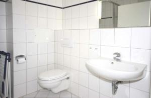 een witte badkamer met een toilet en een wastafel bij Strandschloesschen-Haus-II-WE-11-9644 in Kühlungsborn