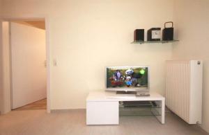 een kamer met een witte tafel en een televisie. bij Strandschloesschen-Haus-II-WE-11-9644 in Kühlungsborn
