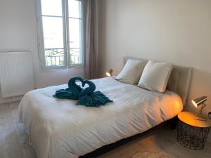 a bedroom with a bed with a blue bow on it at Douillet BY DREAM APARTMENTS in Serris