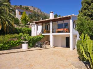 a white house with a balcony and a patio at Villa Stefan - Plusholidays in Calpe