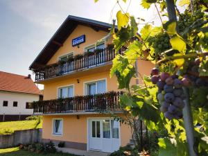 un edificio con balcón y un montón de uvas en Guest House Toic, en Korenica