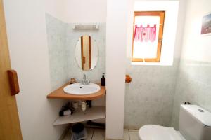 a bathroom with a sink and a toilet and a mirror at La Ptite Auberge in Aiguilles