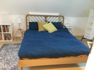 ein Bett mit blauer Bettwäsche und Kissen in einem Schlafzimmer in der Unterkunft Numéro 7 in Le Tronquay