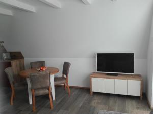 a living room with a table and a flat screen tv at Finnhütte Bernstein in Gager