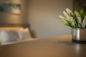 wazon wypełniony białymi kwiatami siedzącymi na stole w obiekcie Eleton Resort & Spa w mieście Villa Carlos Paz