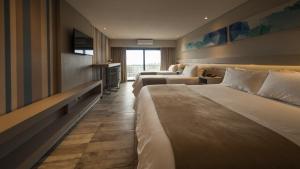 a hotel room with two beds and a television at Eleton Resort & Spa in Villa Carlos Paz