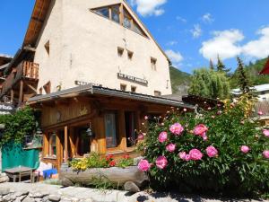 un edificio con dei fiori di fronte di La Ptite Auberge ad Aiguilles