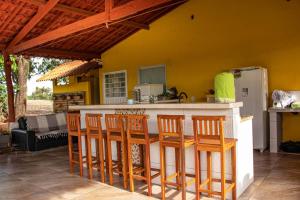 uma cozinha com um bar com cadeiras à volta em Chalés praia vermelha em São João Batista do Glória