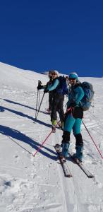 2 persone sugli sci su una pista innevata di La Ptite Auberge ad Aiguilles