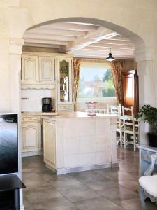 CoutrasにあるVilla Margueriteの白いキャビネットと大きな窓付きのキッチン