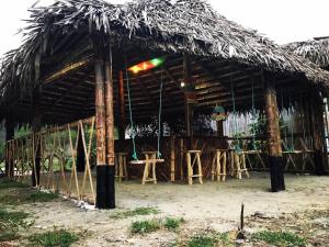 una capanna con tetto di paglia sulla spiaggia di Hostal San Andrés de k-noa a Canoa