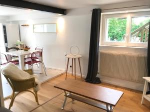 a living room with a table and chairs and a window at Côté Verger in Vittel