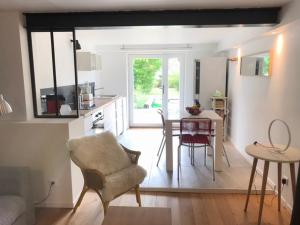 a kitchen and living room with a table and a chair at Côté Verger in Vittel