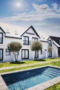 a house with a swimming pool in front of it at Giardino Boutique Hotel in Swakopmund