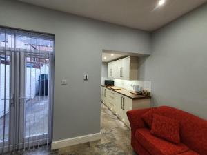 a living room with a red couch and a kitchen at The Shed in Darlington