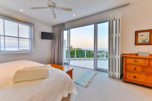 a bedroom with a bed and a sliding glass door at Plettenberg View in Plettenberg Bay