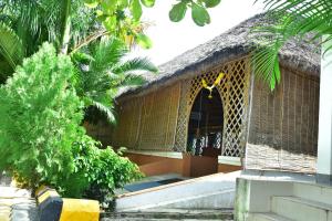 een ingang naar een gebouw met een rieten dak bij Megha Resort , Hampi in Hampi