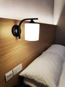 a bedroom with a bed with a lamp on it at EZ Suites in Bandar Seri Begawan