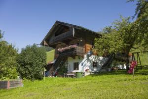 una casa con un balcón en el lateral. en Bergbauernhof Hinterseebach, en Oberaudorf