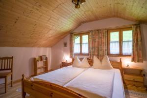 a bedroom with a large bed with a wooden ceiling at Bergbauernhof Hinterseebach in Oberaudorf