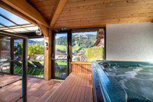 a large swimming pool in a house with a deck at Hôtel Les Côtes, Résidence Loisirs et Chalets in Morzine