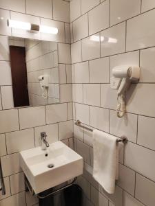 a white bathroom with a sink and a mirror at EZ Suites in Bandar Seri Begawan