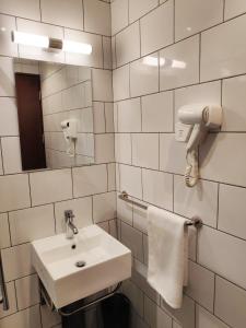 EZ Suites في بندر سيري بيغاوان: حمام أبيض مع حوض ومرآة